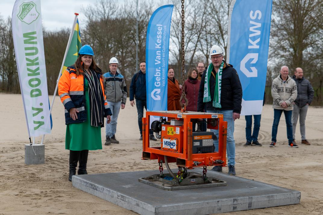 Wethouder Rebecca Slijver en voorzitter Herman Bakker van VV Dokkum plaatsen de eerste platen voor het kunstgrasveld van de voetbalvereniging